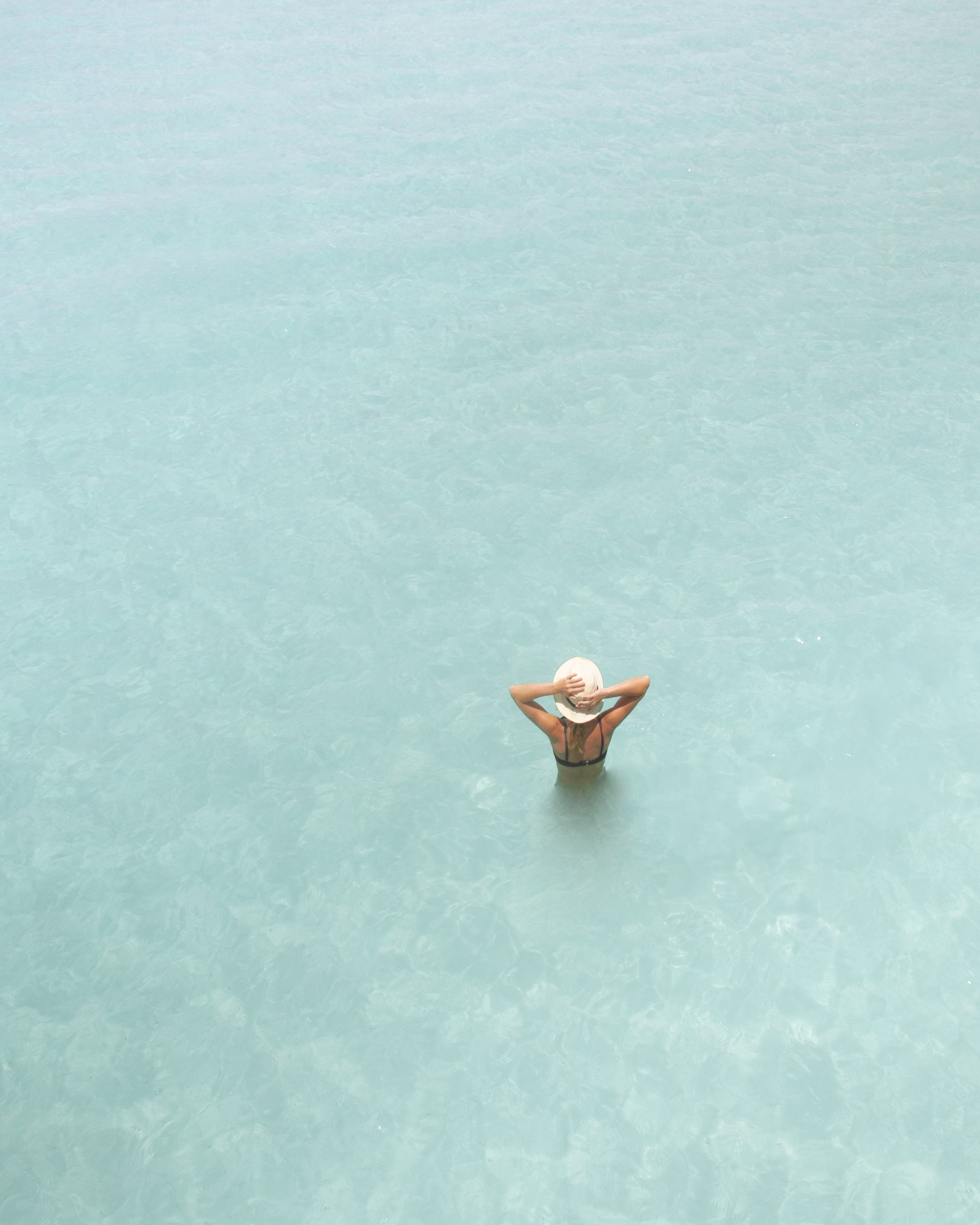 Woman sea in the summer holding the hat