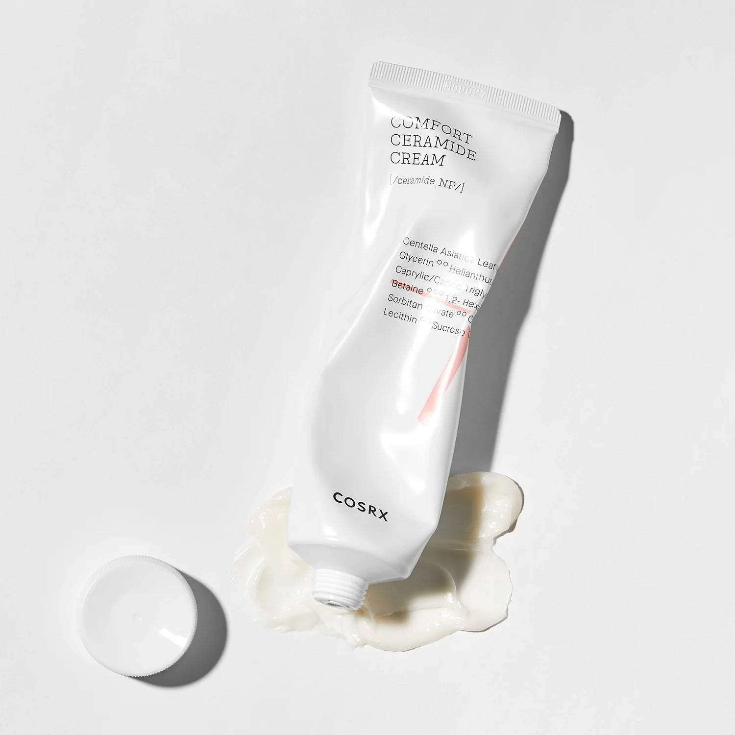 Cosrx Comfort Ceramide Cream laying down with texture and white background