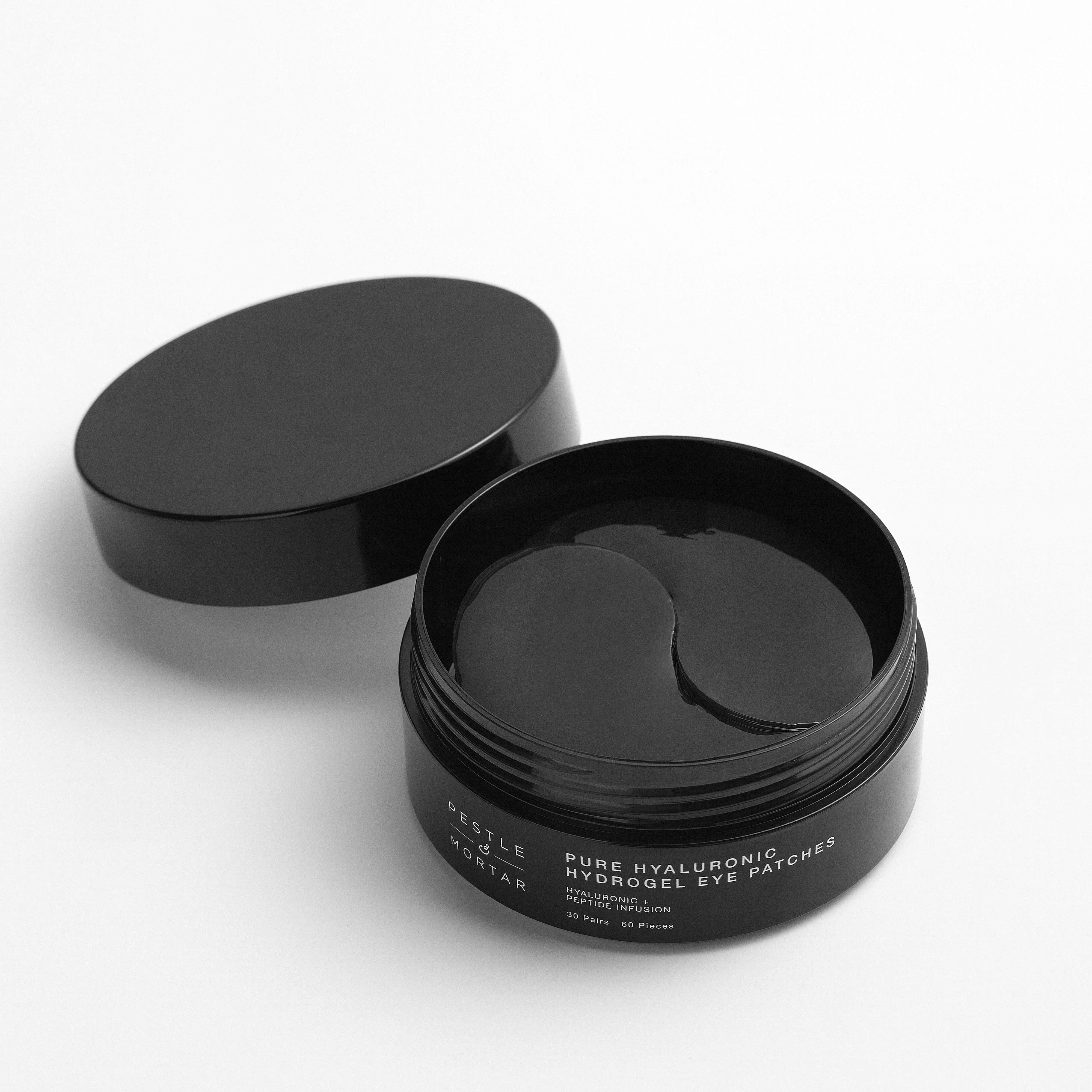 Open black jar of pestle & mortar pure hyaluronic hydrogel eye patches with eye patches on a white background
