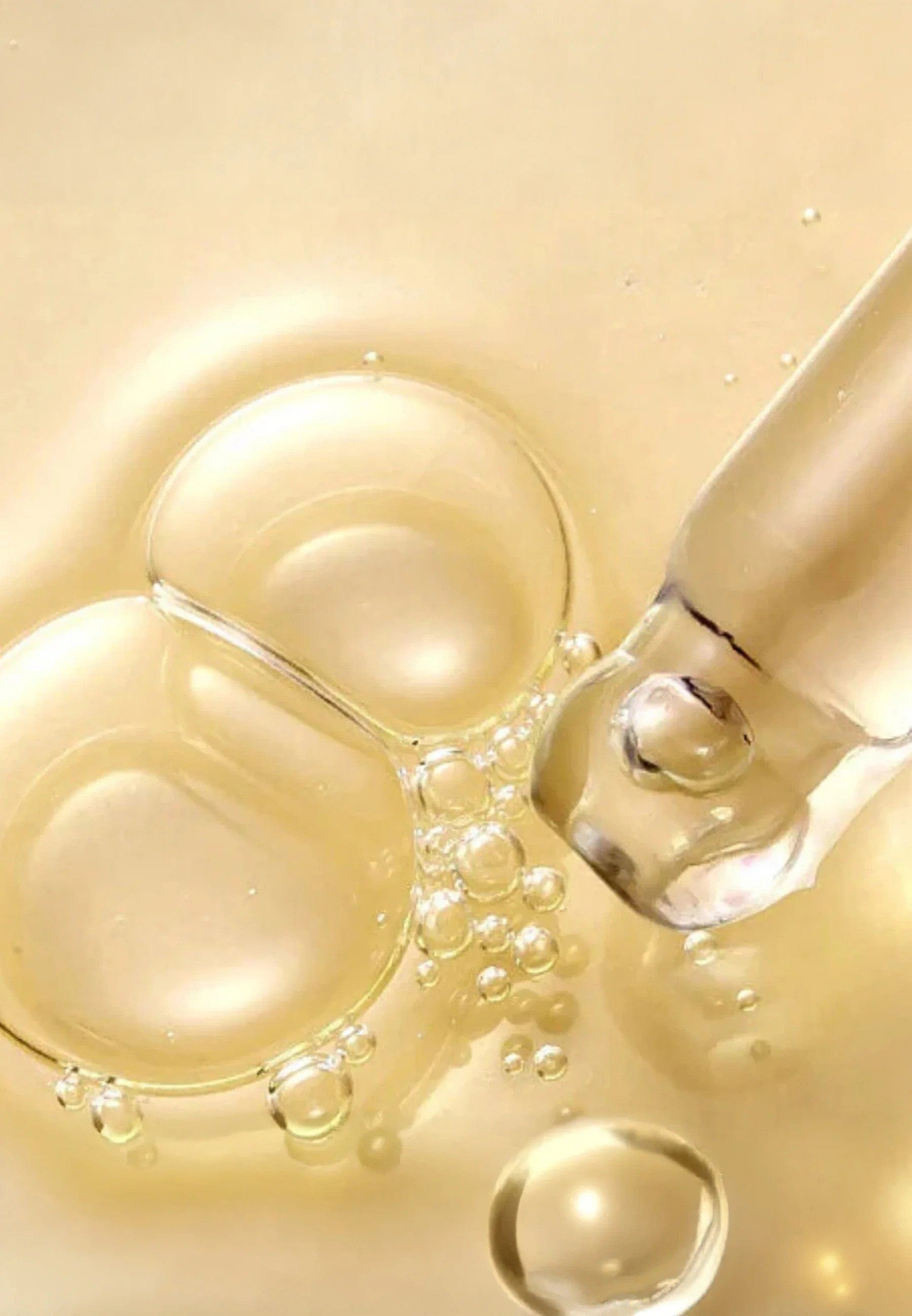 Medicube AGE-R Vita C Pro Ampoule  Close-up of a dropper with liquid on a beige background